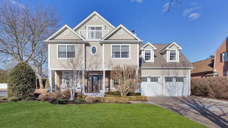 Two-story home with a well-manicured grass lawn and driveway, epitomizing suburban elegance.