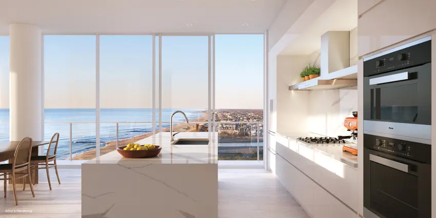 Elegant kitchen with marble finishes and panoramic ocean views, blending luxury with scenic beauty.
