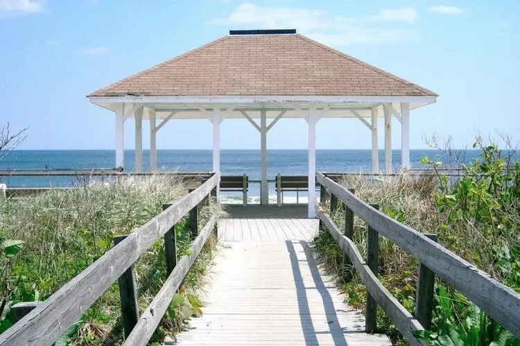 Sunny day at Jersey Shore, featuring the beach and a pergola, embodying a serene coastal ambiance.
